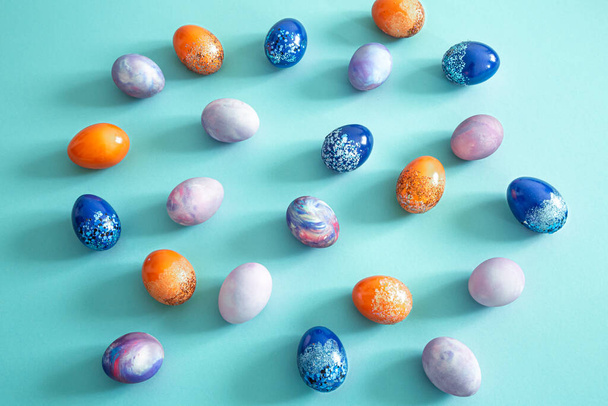 Pääsiäisen värilliset munat värillisellä taustalla. Pääsiäisen tausta on paljon munia. Pääsiäislomien käsite
. - Valokuva, kuva