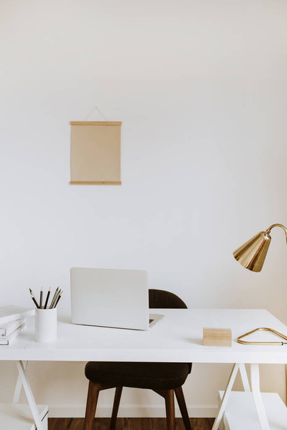 Modern minimal interior design concept. Bright Scandinavian home office desk table workspace with laptop, lamp, books. Business study cabinet. Girl boss studio concept. - Foto, imagen
