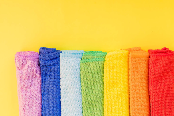 kleurrijke microvezel handdoeken, over gele achtergrond.Reiniging microvezel doek geïsoleerd, Opgevouwen schoonmaken textiel servetten kleurrijke stapel. Huishoudelijke schoonmaakdienst concept.Kopieerruimte - Foto, afbeelding
