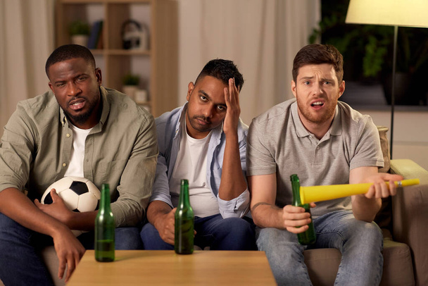 sad male friends or soccer fans with beer at home - Foto, imagen