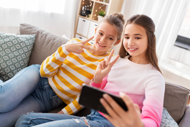 happy girls taking selfie with smartphone at home - Zdjęcie, obraz