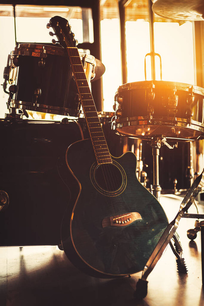 Guitar sitting on the ground and sun light at music studio. - Foto, imagen