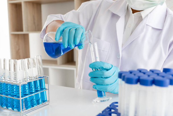 Medycy eksperymentowali z ciekłymi chemikaliami in vitro w celu analizy danych wirusowych w laboratoriach chemicznych. Koncepcje badań naukowych. - Zdjęcie, obraz