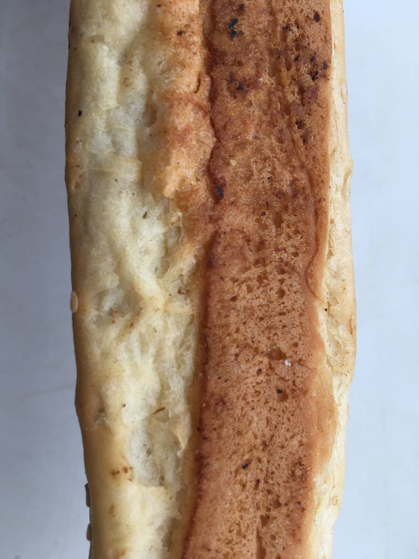 Makró felvétel egy kenyértekercsről fehér háttérrel. Absztrakt tapéta. - Fotó, kép