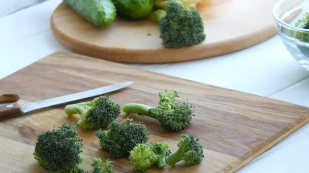 Cortar la col de brócoli verde fresca cruda en una placa de cocina. Cocine las verduras cortadas con un cuchillo. Comida vegana
. - Metraje, vídeo