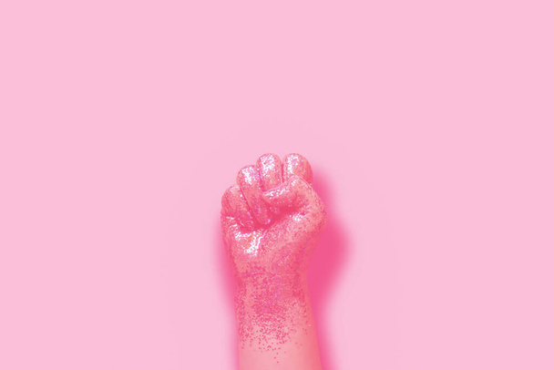 woman fist covered in pink glitter on pink background - Photo, Image