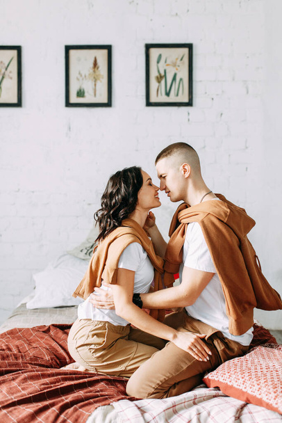 Beautiful couple on the bed. Love story in the interior Studio. Happy and laughing people. At home, having fun on the bed. - Foto, Imagem