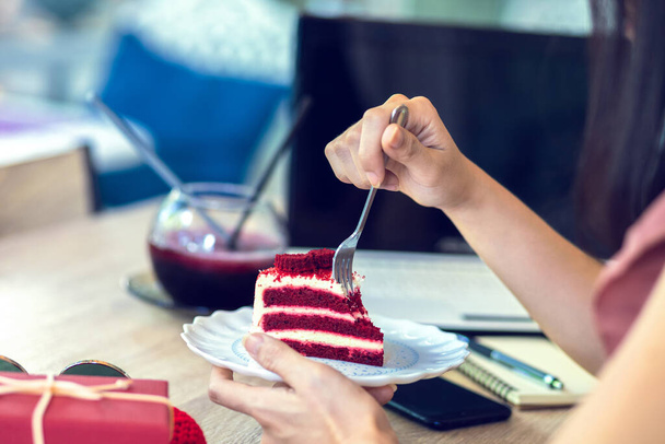 Hand hold fork for eating Red Velvet strawberry cheese cake. - Valokuva, kuva