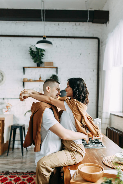 Beautiful couple preparing food. Love story in the interior Studio. Happy and laughing people. Breakfast is served in the kitchen. - Foto, immagini