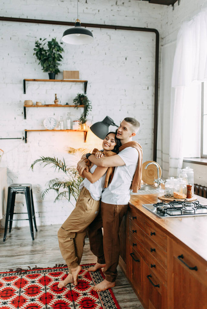 Beautiful couple preparing food. Love story in the interior Studio. Happy and laughing people. Breakfast is served in the kitchen. - Valokuva, kuva