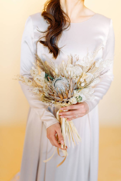 Stylish bouquet for a wedding in the style of finart. Fall bride's bouquet. Floristics of dried flowers.  - Zdjęcie, obraz
