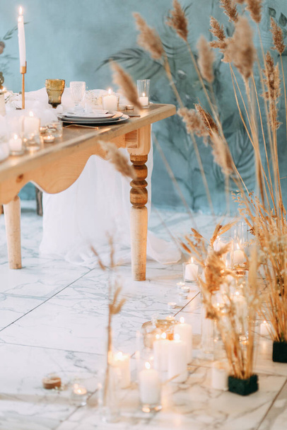 The decor of the ceremony is made of dried flowers. Burning candles on fire in the decor. Autumn wedding decor.  - 写真・画像