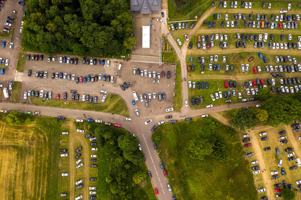 Drohnen-Blick auf den Parkplatz des Musikfestivals am Ende des Festivals mit Menschen, die das Gelände verlassen. - Foto, Bild