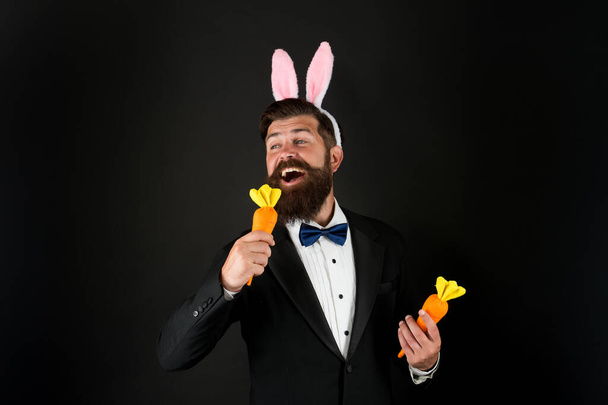 Celebration Easter holiday. Easter day. Event host. Celebrate Easter. Bearded man with long ears. Businessman with long ears. Handsome man wear bunny costume accessory. Carrot is good for your teeth - Photo, image