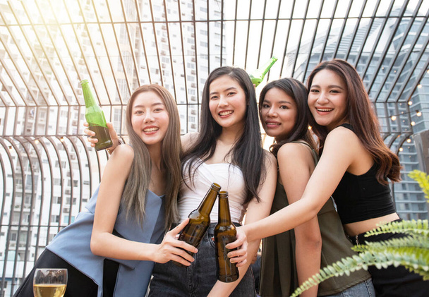 Egy csapat fiatal ázsiai nő barátjának boldog pillanata van, hogy megünnepeljék a táncpartit egy üveg sörrel a kezében a nightclubban.. - Fotó, kép