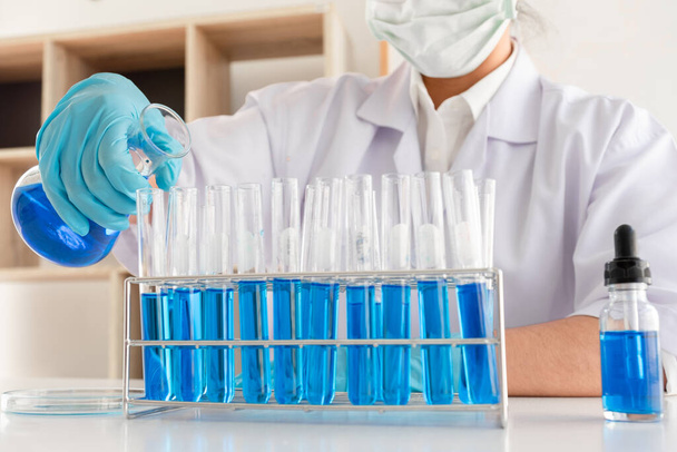 Медицинские ученые экспериментировали с жидкими химикатами in vitro для анализа вирусных данных в химических лабораториях. Научные исследования. - Фото, изображение