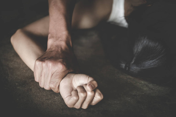 Мужчина держит за руку женщину за изнасилование и сексуальное насилие, изнасилование в семье, концептуальное фото сексуального насилия, Международный женский день - Фото, изображение