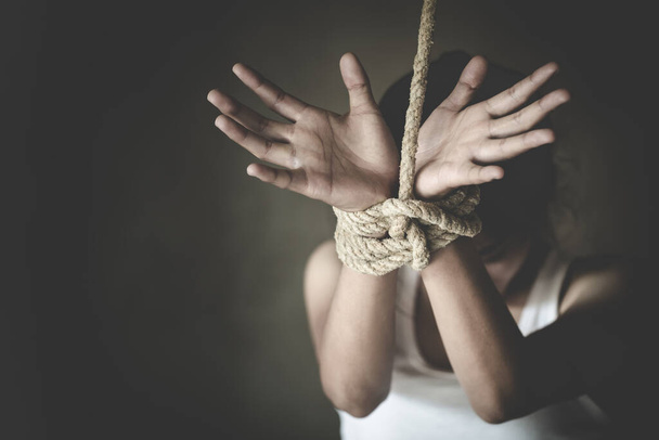 Porwana kobieta związana liną, maltretowana, zakładniczka, cierpiąca kobieta, handel ludźmi, prawa człowieka. - Zdjęcie, obraz