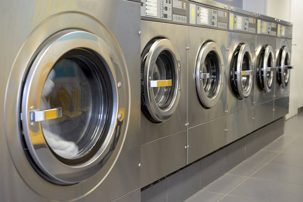 Máquinas de lavar alinhadas em uma lavanderia
 - Foto, Imagem