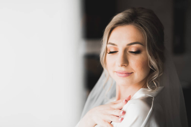 Schöne Braut trägt Mode Hochzeitskleid mit Federn mit luxuriösem Genuss Make-up und Frisur, Studio Indoor Fotoshooting - Foto, Bild