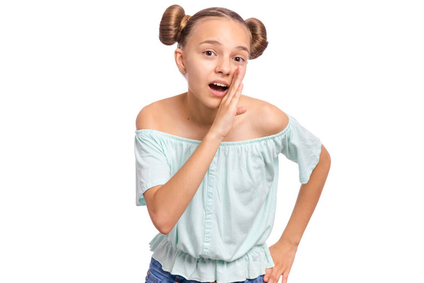 Portret van tienermeisje houdt haar hand bij haar mond en praat iets, geïsoleerd op witte achtergrond. Schattig Kaukasisch jong tiener fluisteren roddels. - Foto, afbeelding