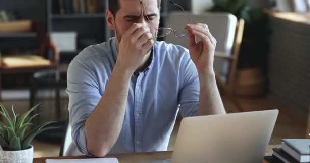 Exhausted businessman taking off glasses massaging dry irritated eyes - Кадри, відео
