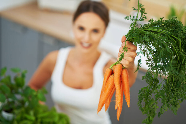 Здоровая взрослая женщина с зеленой пищей на кухне
 - Фото, изображение