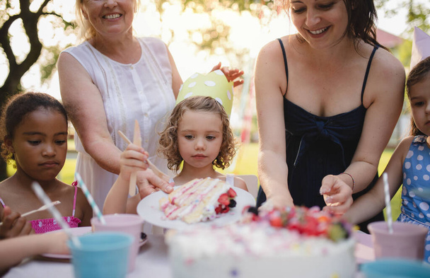 Kids birthday party outdoors in garden in summer, celebration concept. - Zdjęcie, obraz