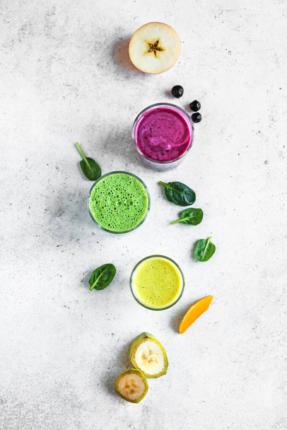 Colorful Smoothie Drinks for healthy detox breakfast, top view, copy space. Three various green, yellow, purple smoothies with ingredients. Vegan raw food, healthy eating concept. - Fotografie, Obrázek