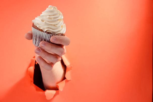 Hand giving a cupcake with buttercream swirl - Fotó, kép