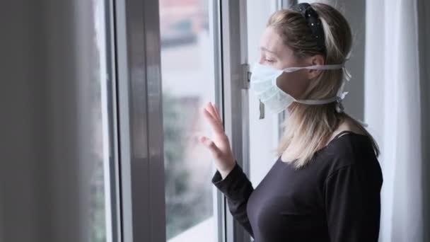 Coronavirus covid-19 Isolation - wackelige Kameraszene einer Italienerin am Fenster mit einer Maske Quarantäne-Maßnahmen während des Virus-Ausbruchs - Filmmaterial, Video