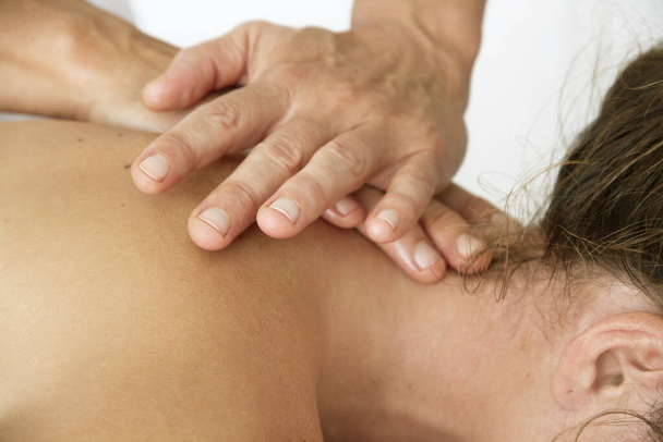 Massaggi e osteopatia a una donna sul collo e sulla schiena
 - Foto, immagini