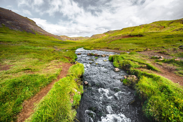 Wunderbare isländische Naturlandschaft. Blick von oben. Hohe Berge, Gebirgsfluss und grüne Wiesen. Grüne Wiesen. Island. - Foto, Bild