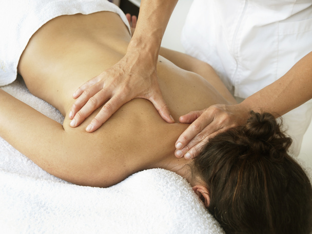Massages en osteopathie aan een vrouw op haar nek en rug - Foto, afbeelding