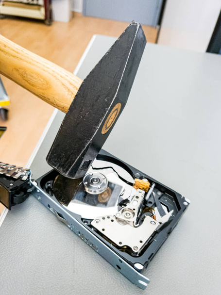 Destroying computer hard drive with a hammer. - Zdjęcie, obraz