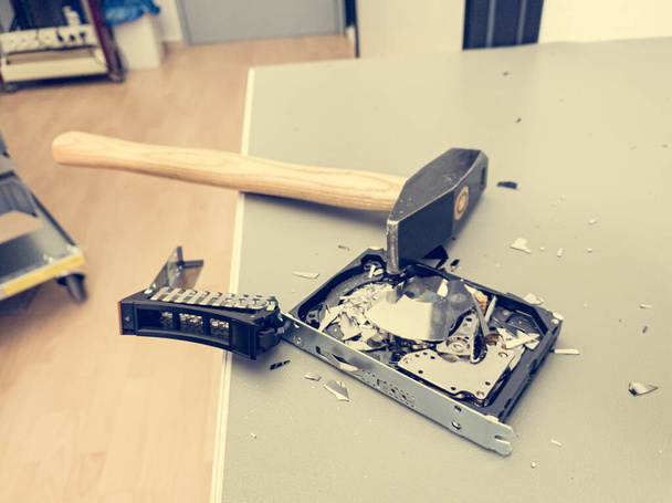Destroying computer hard drive with a hammer. - Foto, afbeelding