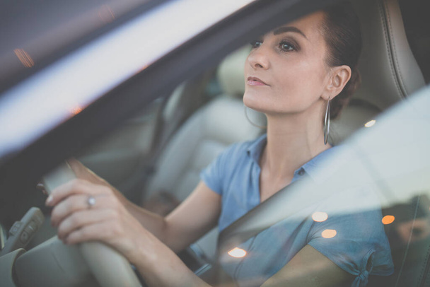 Pretty, young woman  driving a car -Invitation to travel. Car rental or vacation. - Фото, зображення