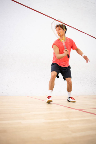 Squash player in action on a squash court (motion blurred image; color toned image) - 写真・画像