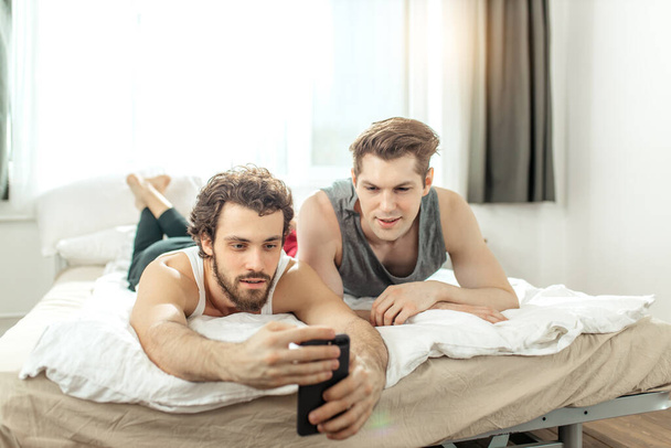 gays watching interesting videos on mobile phone - Фото, изображение