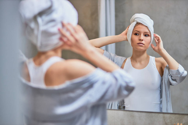 attractive lady look at mirror in bathroom - Foto, Imagen