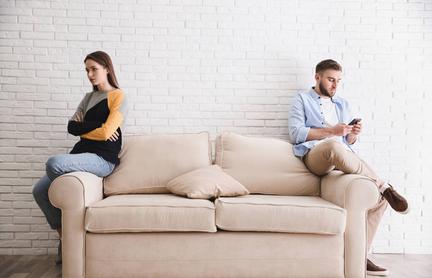 Young man preferring smartphone over his girlfriend at home. Relationship problems - Fotó, kép