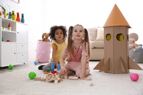 Schattige kleine kinderen spelen met blokken thuis - Foto, afbeelding