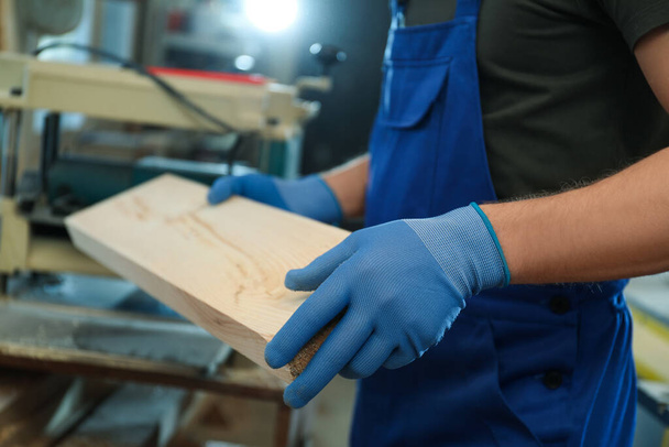 Professional carpenter with wooden board in workshop, closeup - Foto, imagen
