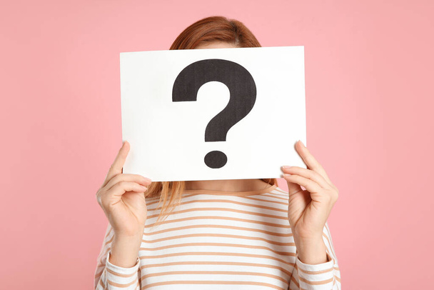 Woman holding question mark sign on pink background - Photo, Image