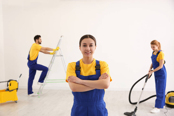 Professional janitor in uniform indoors. Cleaning service - Photo, Image
