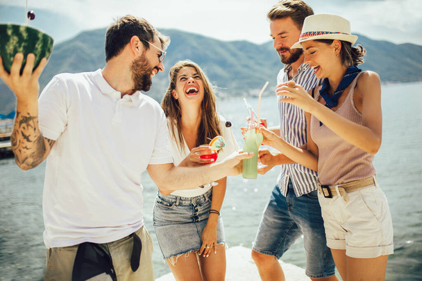 Amici in spiaggia bere cocktail divertirsi in vacanza estiva - Foto, immagini
