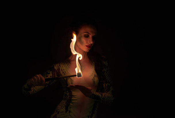 ジャグラー・ガールパイソン・スネークドレスで火ゲームをする - 写真・画像