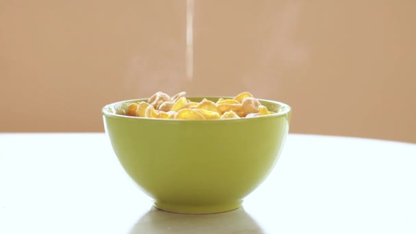 copos de maíz en el plato verde, la leche está fluyendo en el vaso, cámara lenta
 - Metraje, vídeo