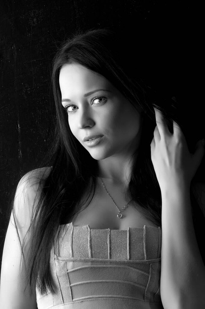 Beautiful sexy brunette girl posing on a black background - Foto, afbeelding