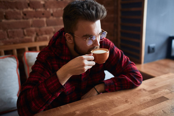 Young serious handsome man drinking coffee - Φωτογραφία, εικόνα